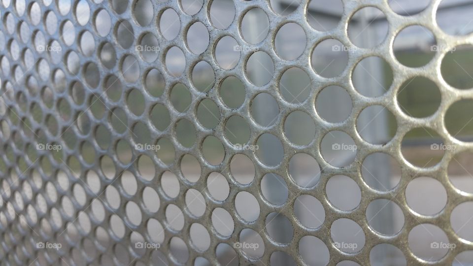 Holes in metal fence