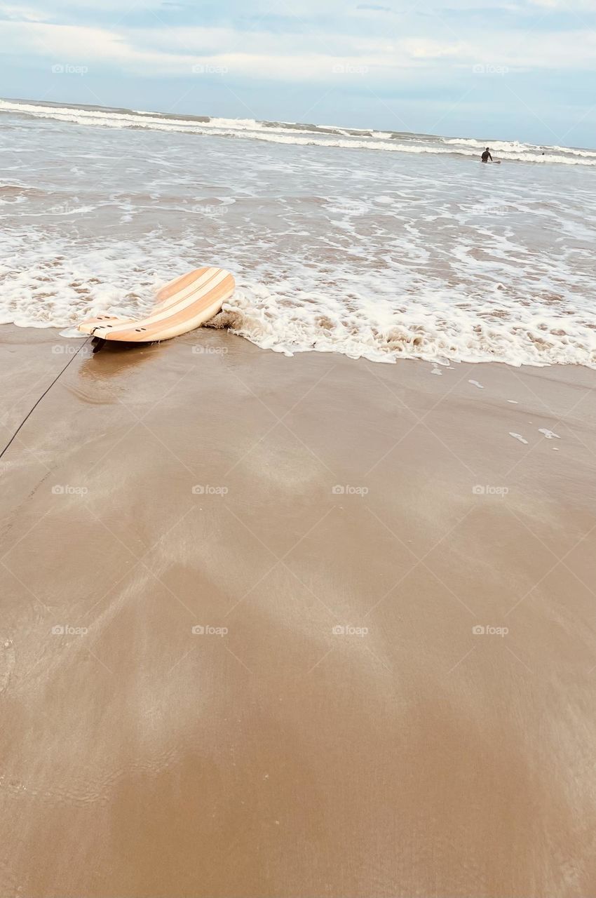 A surf board washing in to shore 