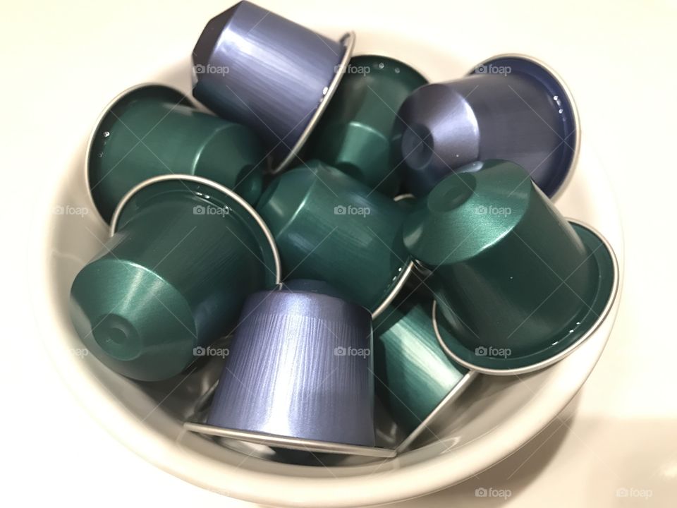 Green and blue coffee capsules on white background 