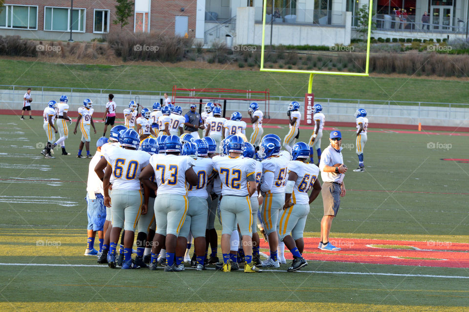 Huddle at Friday night football game. 