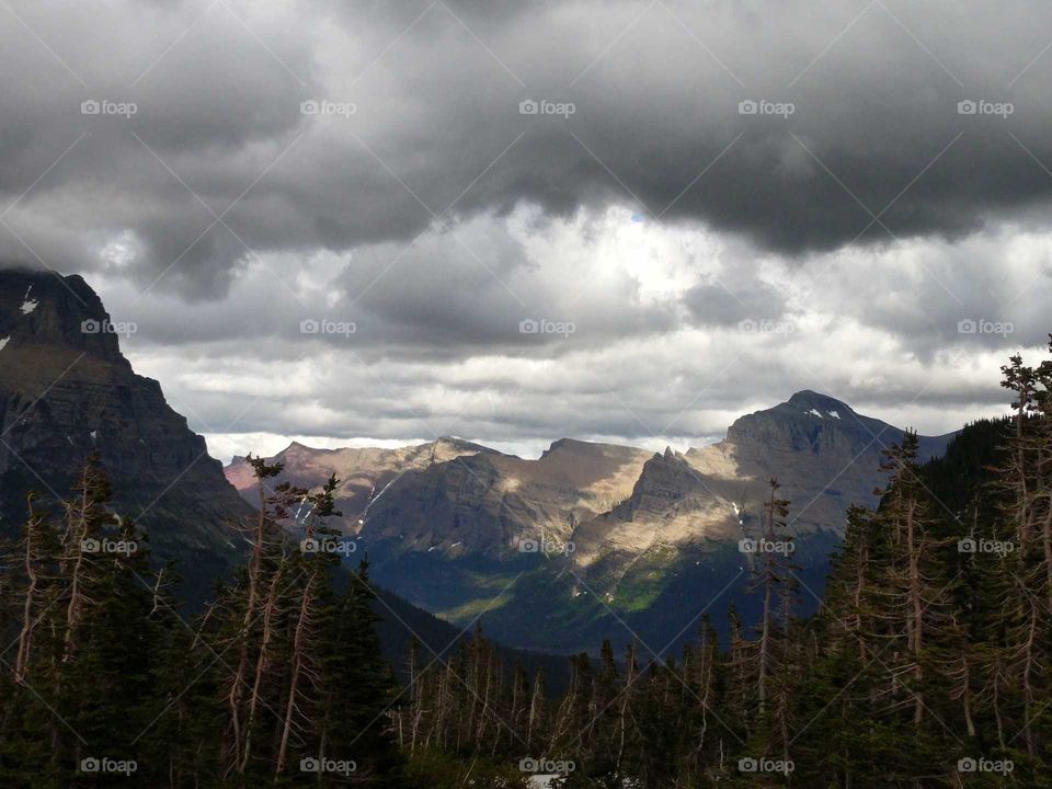 Mountains Lit Up with Dark Cloud Cover Overhead, Glacier National Park, Montana