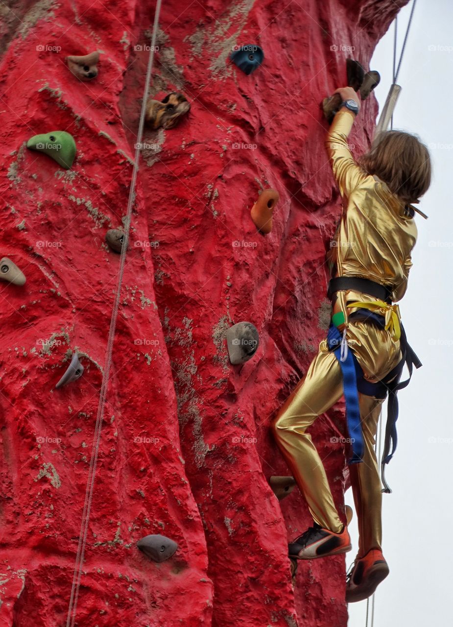 Young Girl Climbing A Rock Wall
