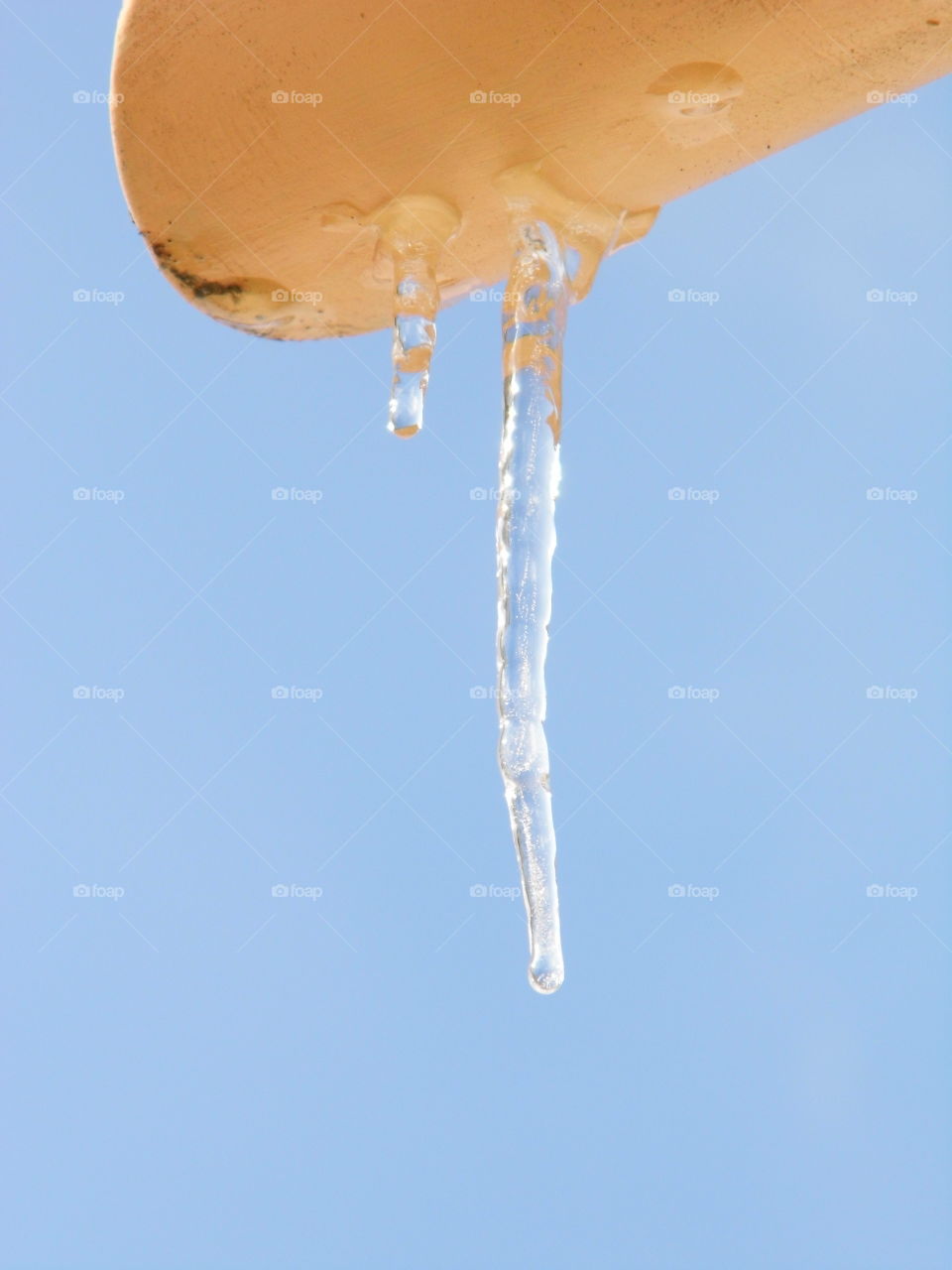 Ice from the roof and beautiful blue sky background