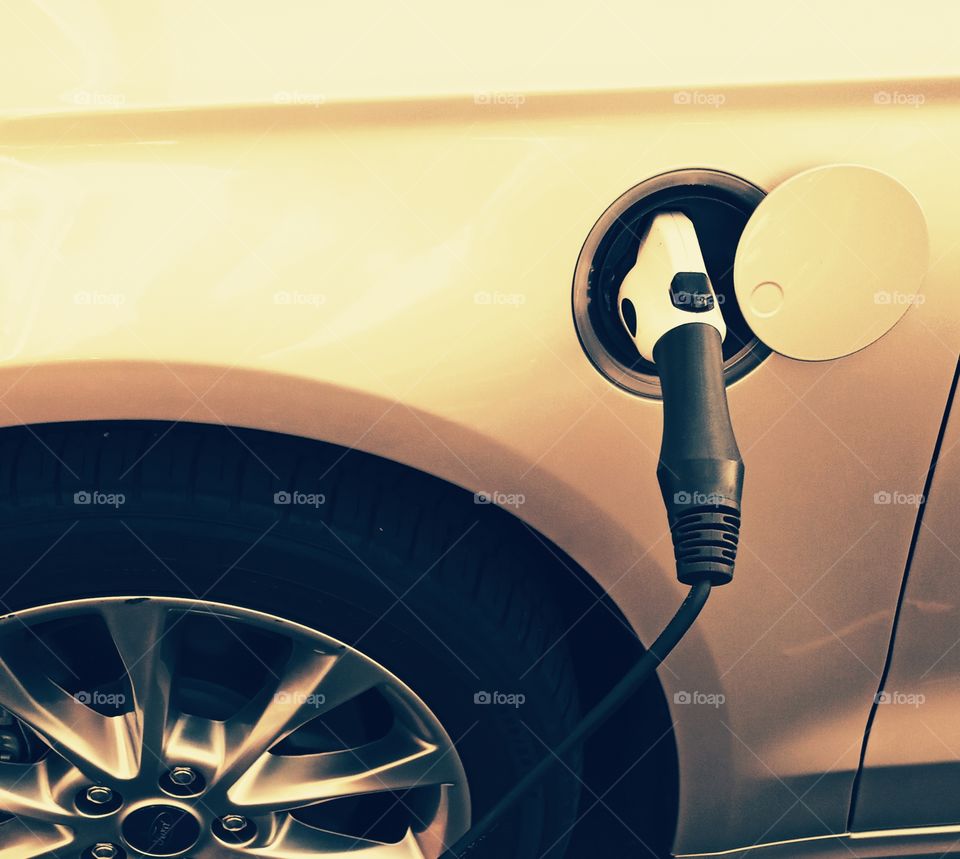 power up, electric car plugged in. clean energy renewable energy.