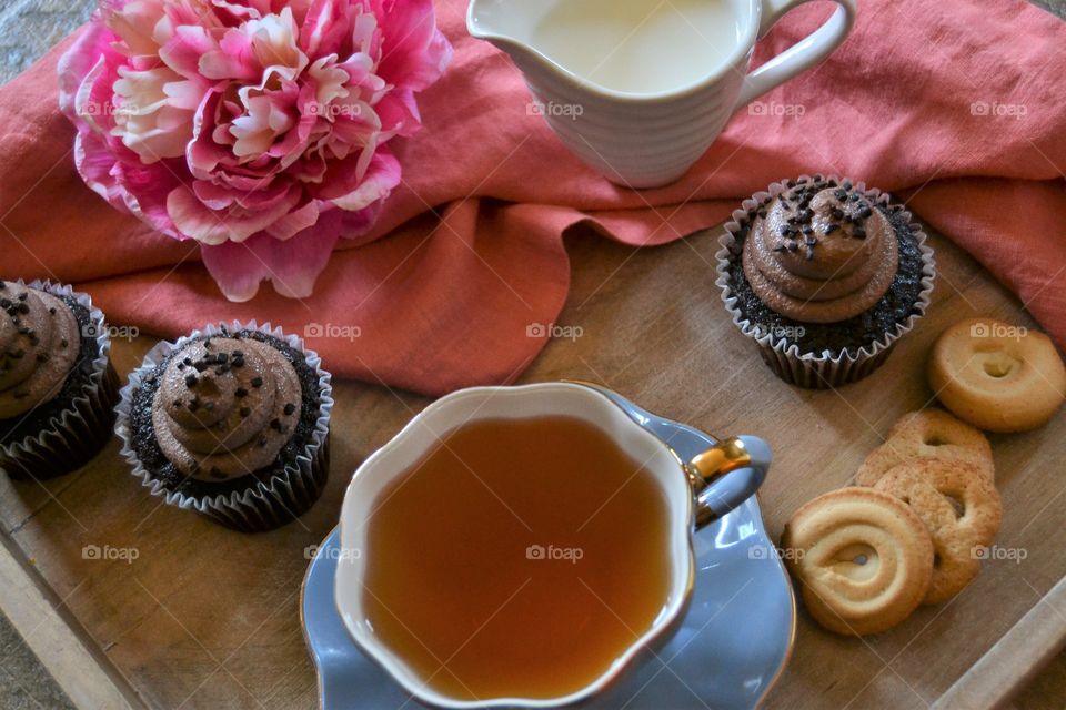 Close-up of tea in teacup with cupcake