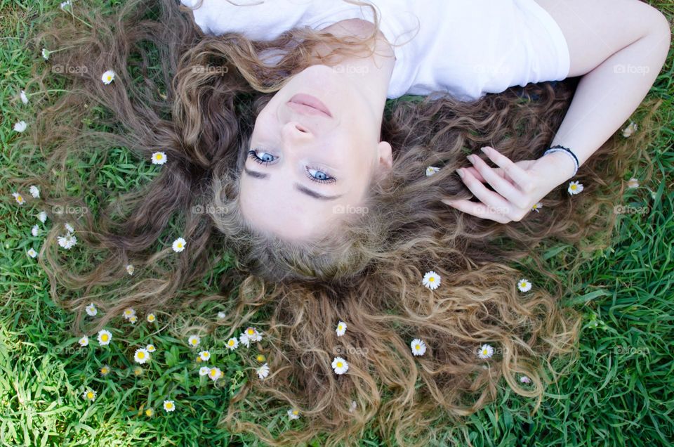 Portrait of a Beautiful Young Girl on Background of Daisies