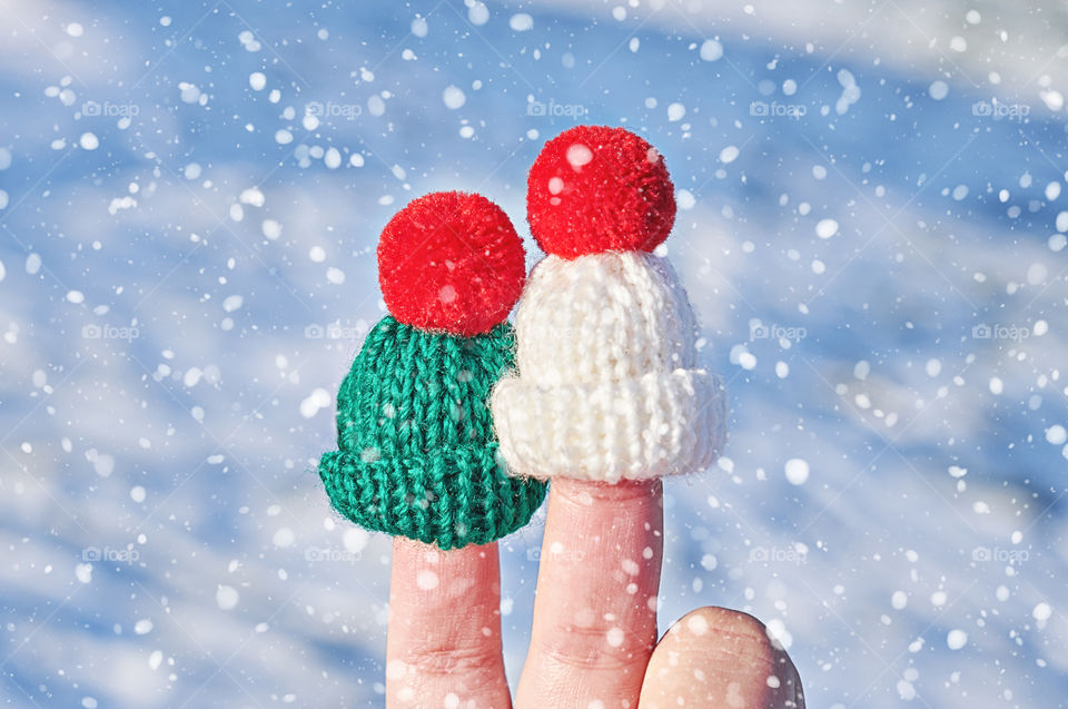 Two woolen hats and fingers