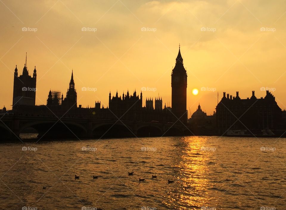 Houses of parliament and Big Ben in silhouette at sunset with moody sky
