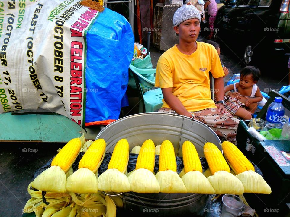 asian street vendor selling steamed corn on a cob in quiapo, manila, philippines in asia