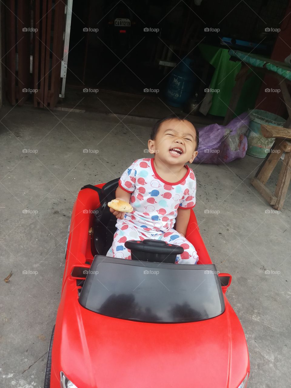a toddler enjoying his new car..
