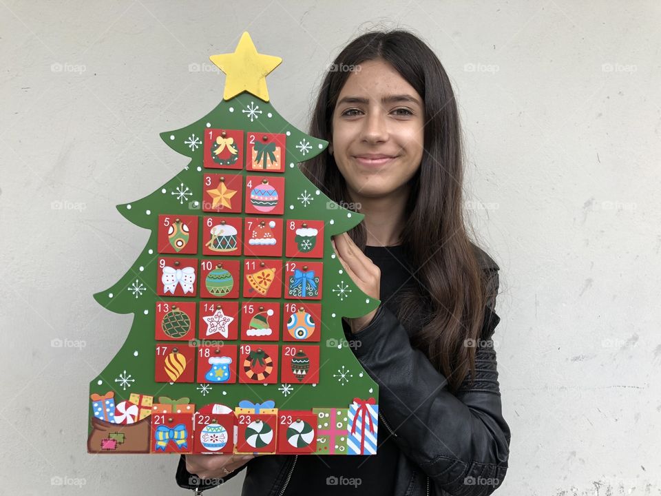 Young girl taking a traditional wooden Advent Calendar