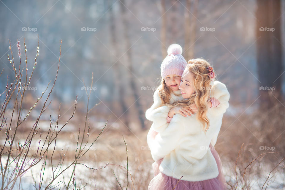 Beautiful mother with daughter at early spring day 