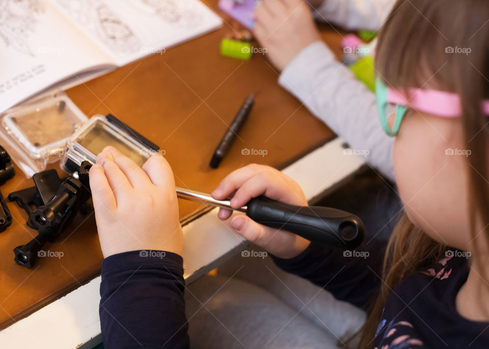 Little girl fixing her toy