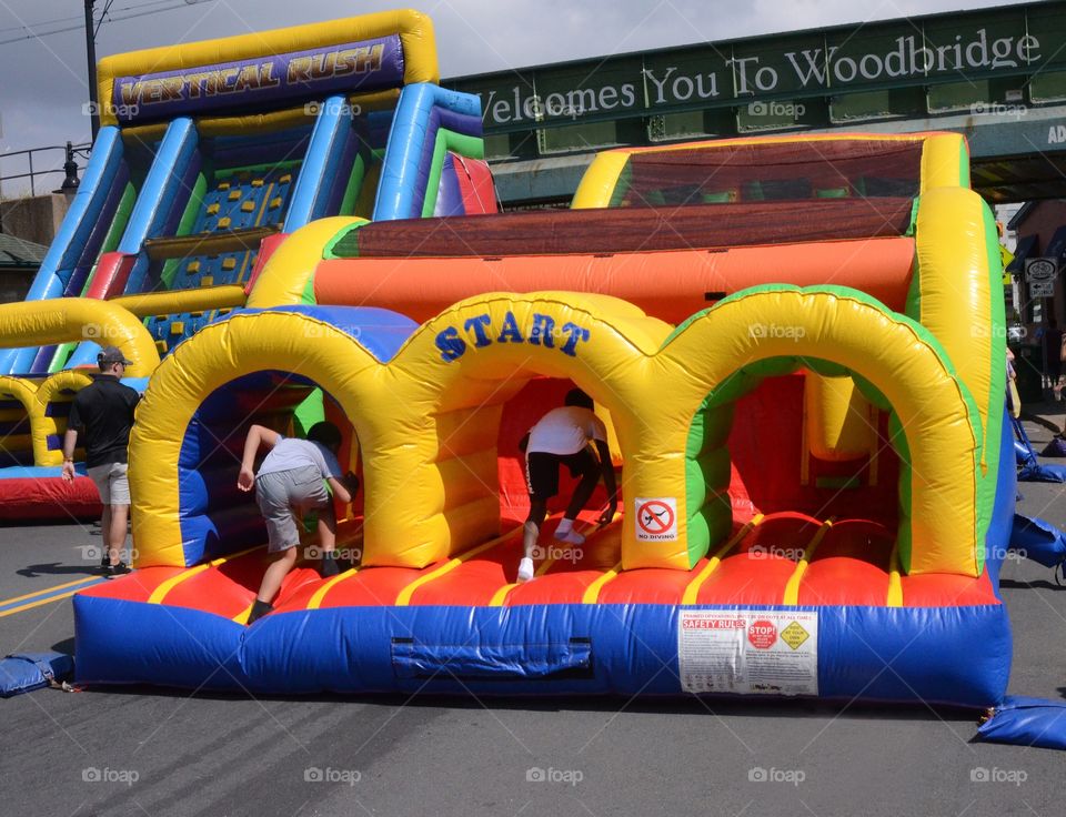 Kids race through an inflatable obstacle course at a local street fair.