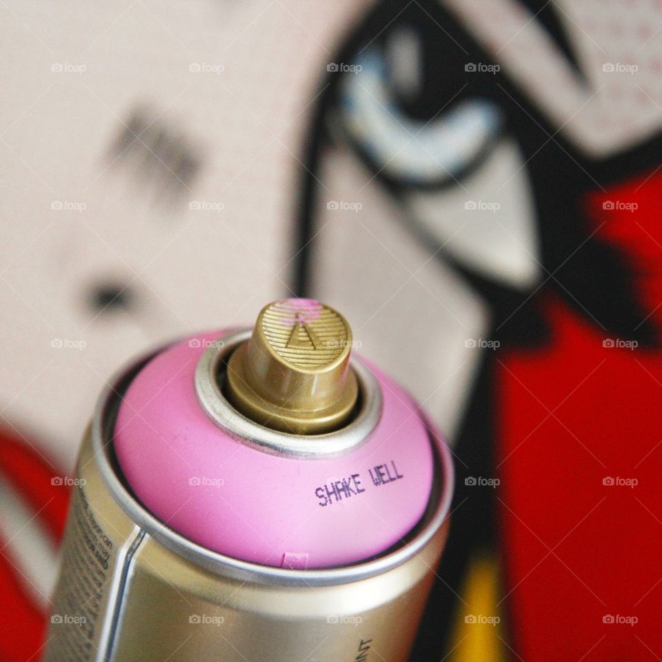 Spray can and art. Pink spray can in front of pop art