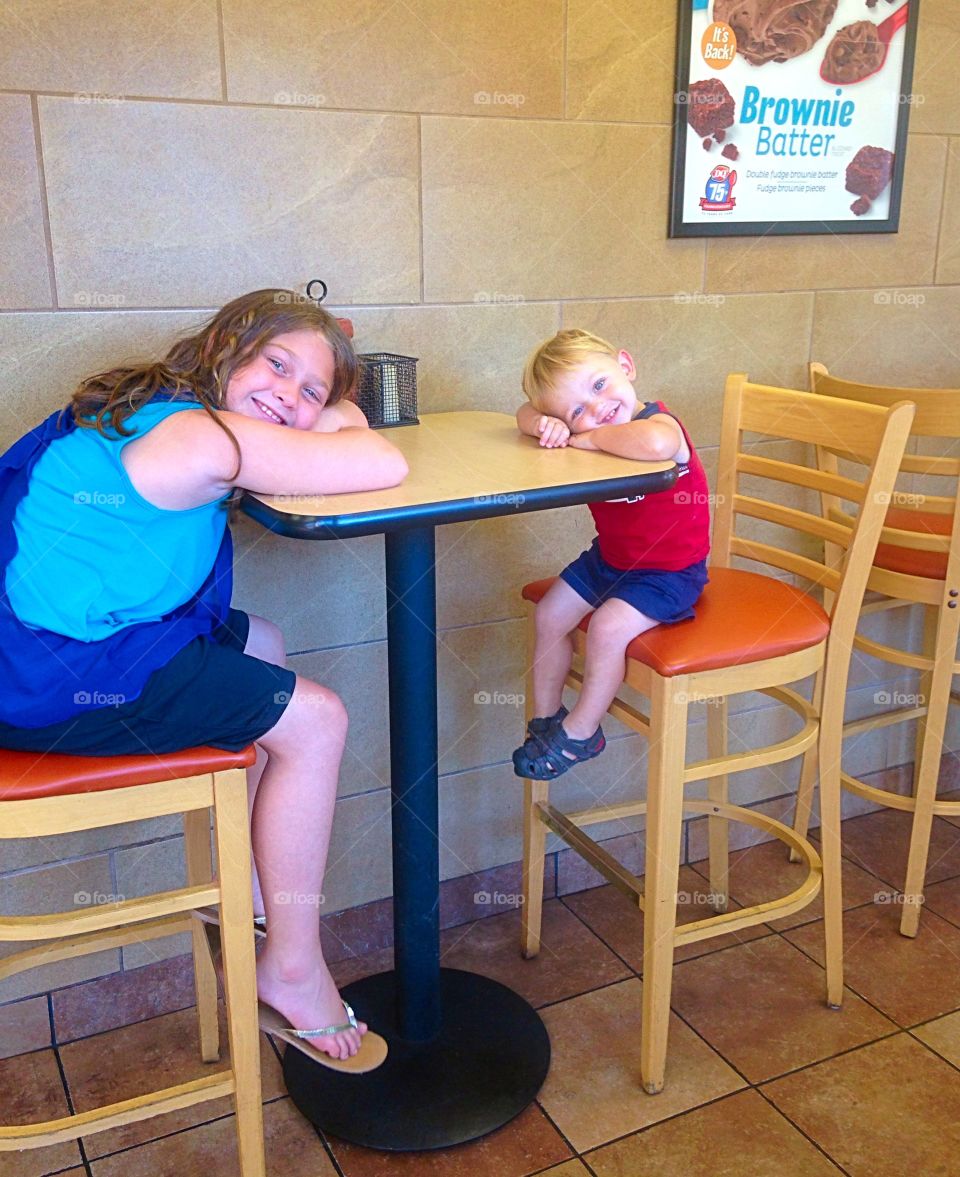 Happy two kids sitting on wooden chair