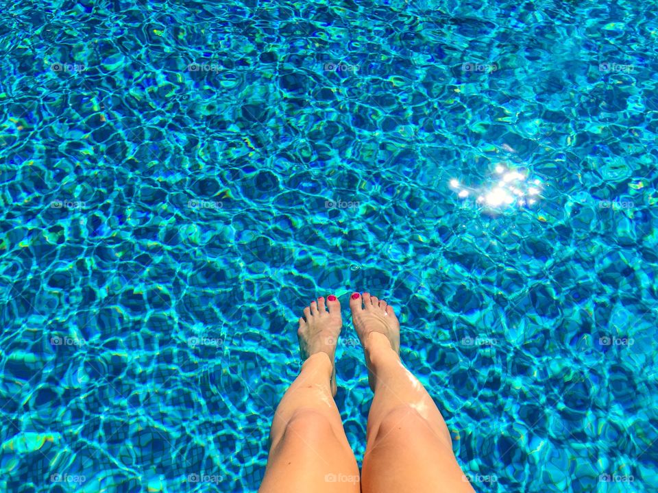 Looking down at woman’s legs in the pool