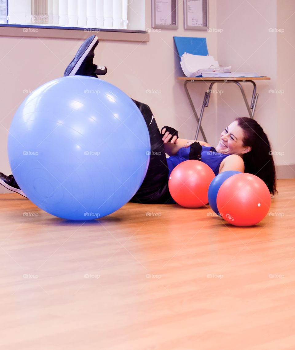 Woman fallen from blue Pilates ball