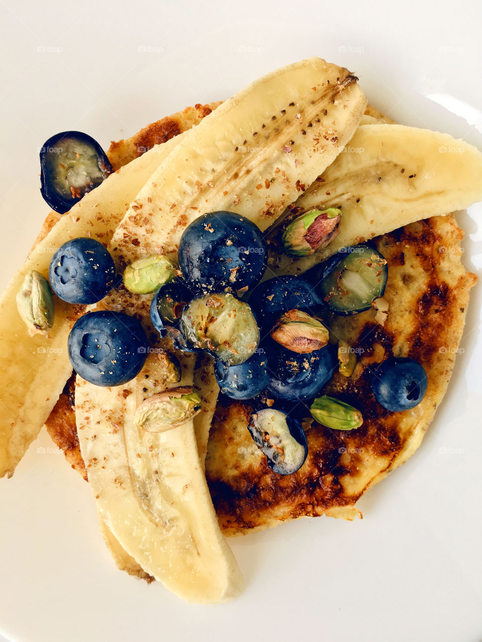 Healthy breakfast with fresh blueberries and banana french toast sprinkle with pistachios