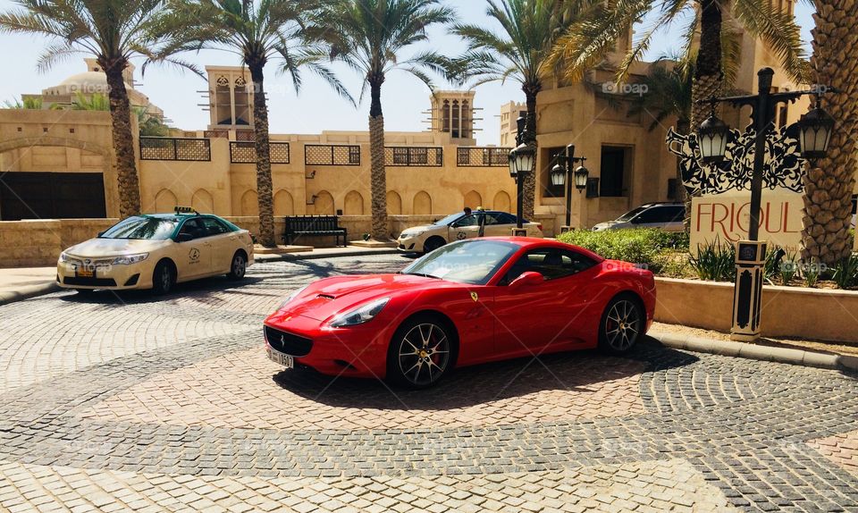A red Ferrari in Dubai with some police cars around 