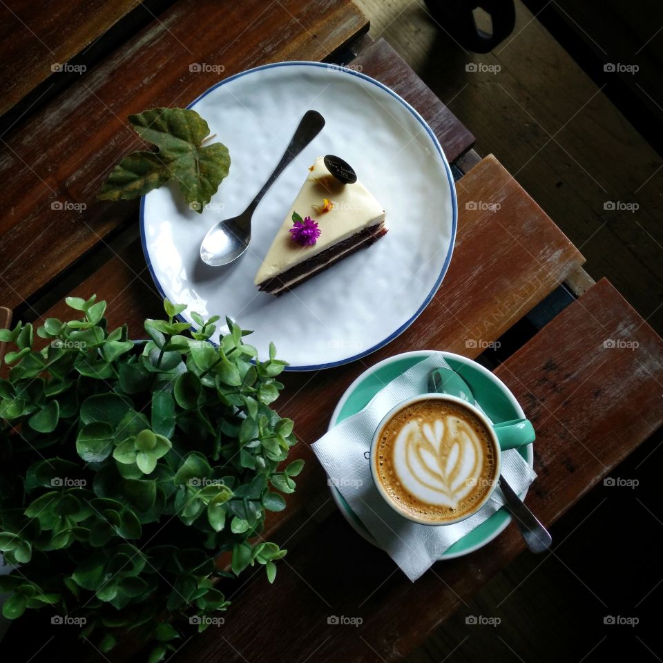 High angle view of cup of coffee with pastry