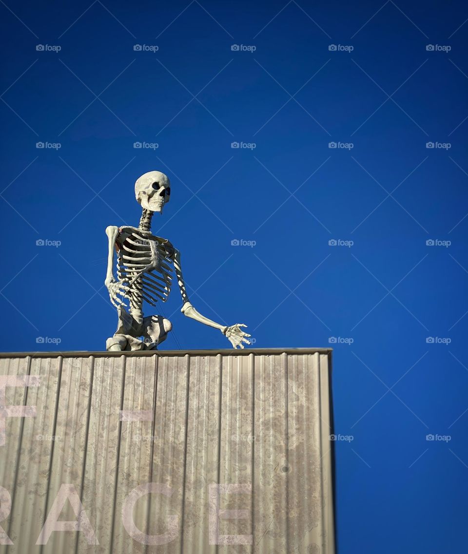 Giant Halloween skeleton on the roof of a self-storage warehouse 