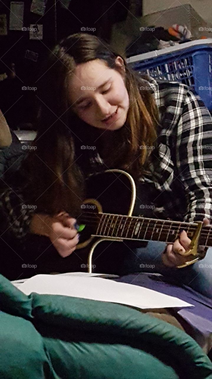 Teenage girl playing guitar