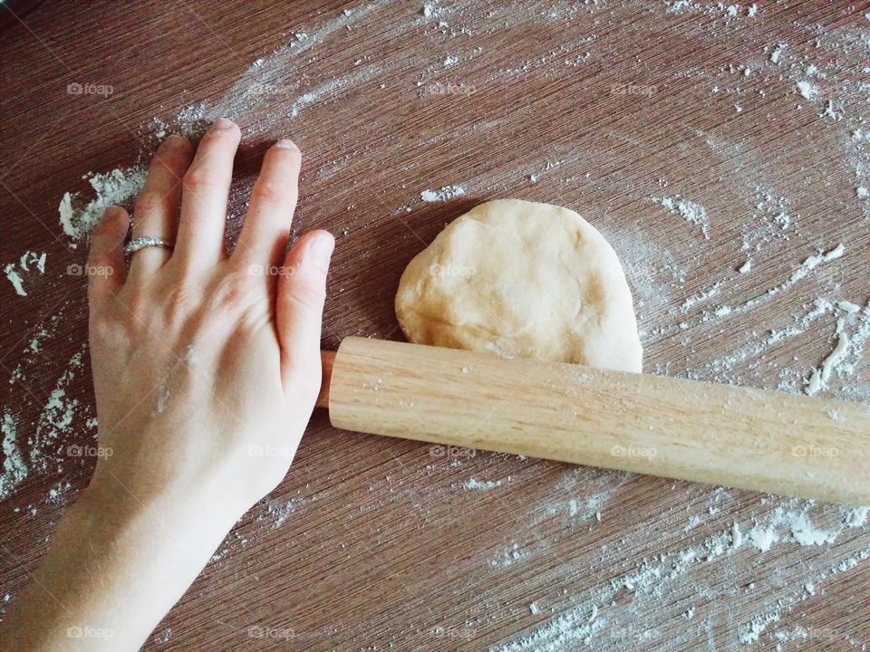 Human's hand preparing dough