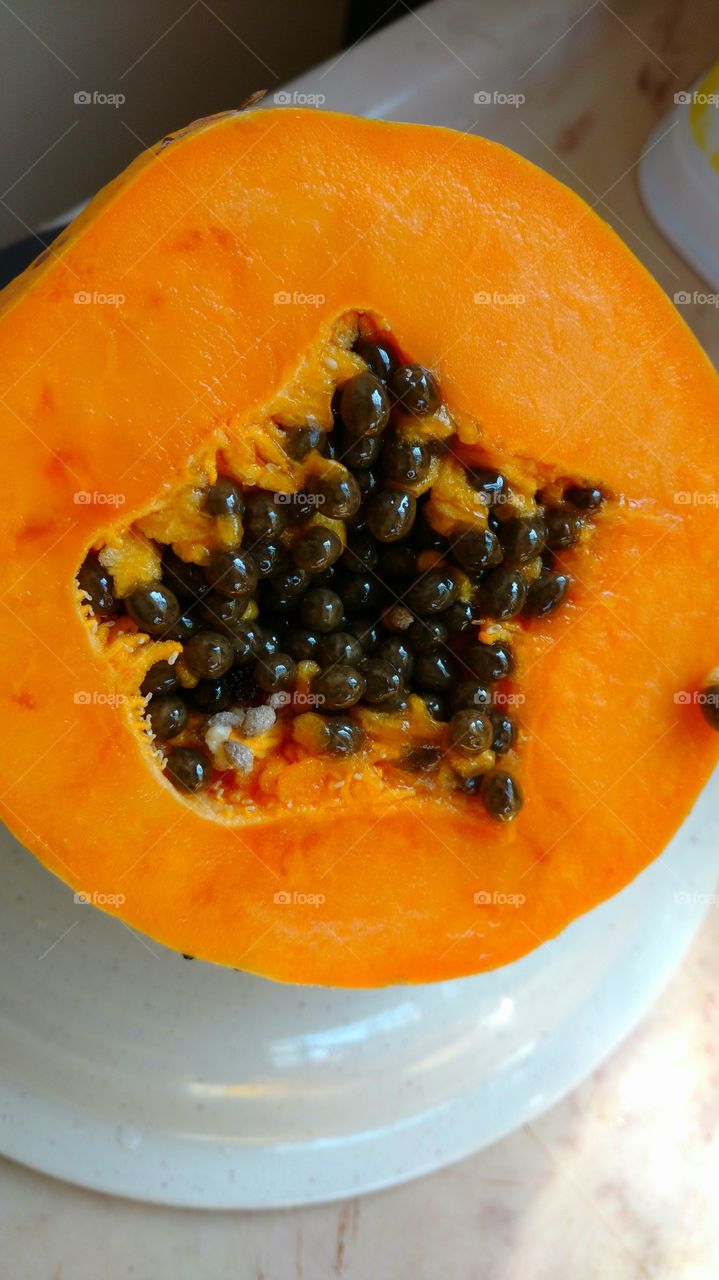 Fruto... mamão cortado ao meio. Interior com as sementes.