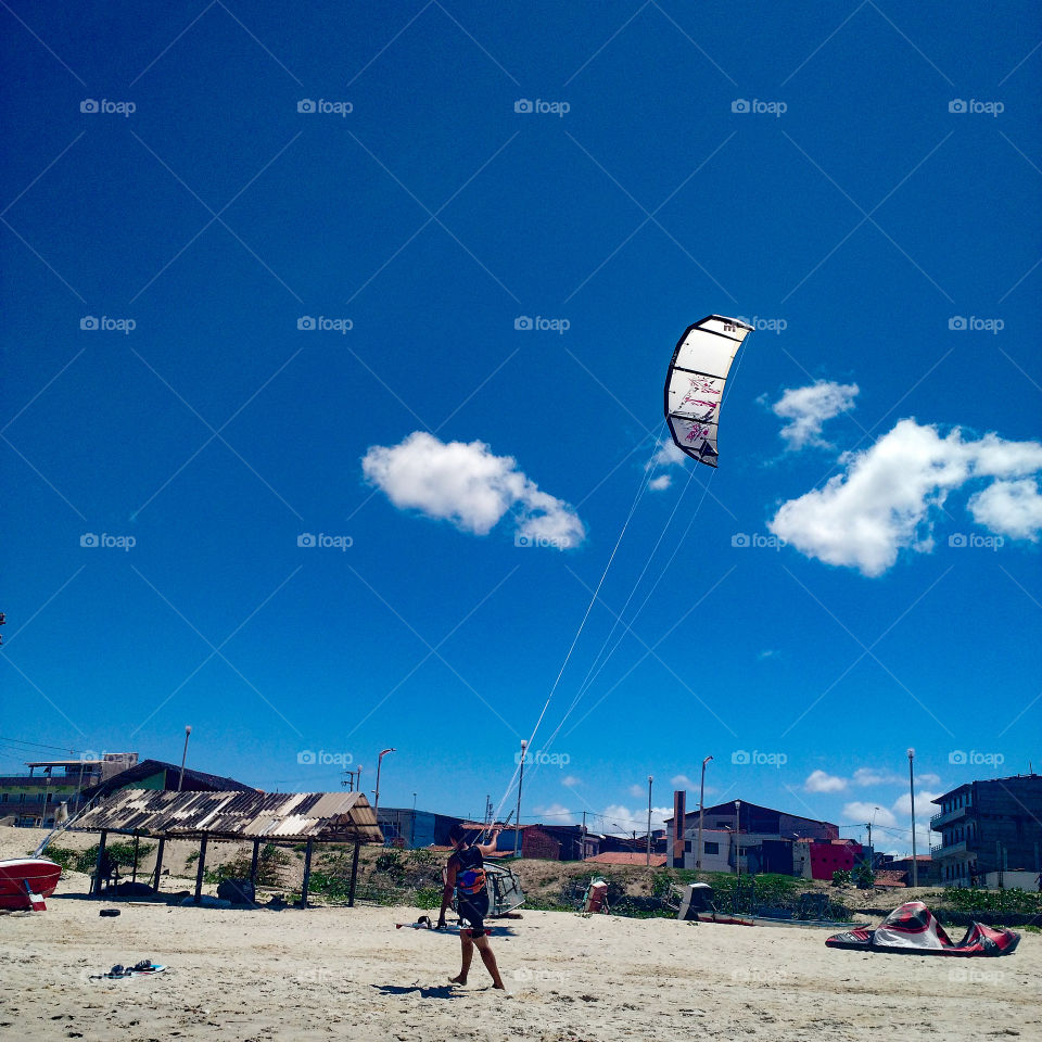 Man at sand with kitesurfing in Brazil