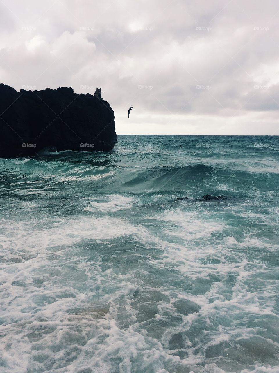 People jumping in stormy sea