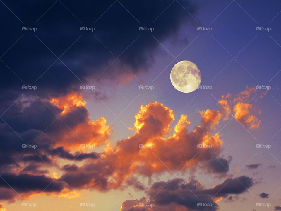 Low angle view of moon in dramatic sky