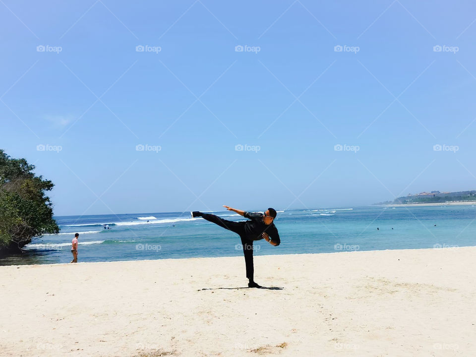 practice side kick of karate on the beach in Bali island