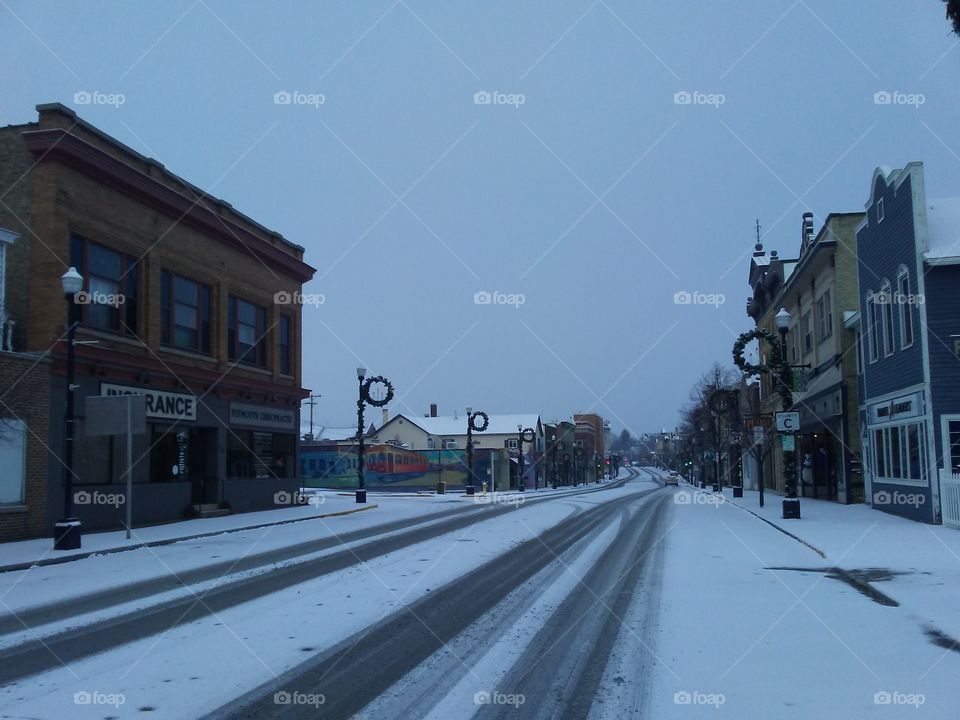 Vehicle tracks on a snow covered Mill Street in downtown Plymouth, Wisconsin Christmas morning.