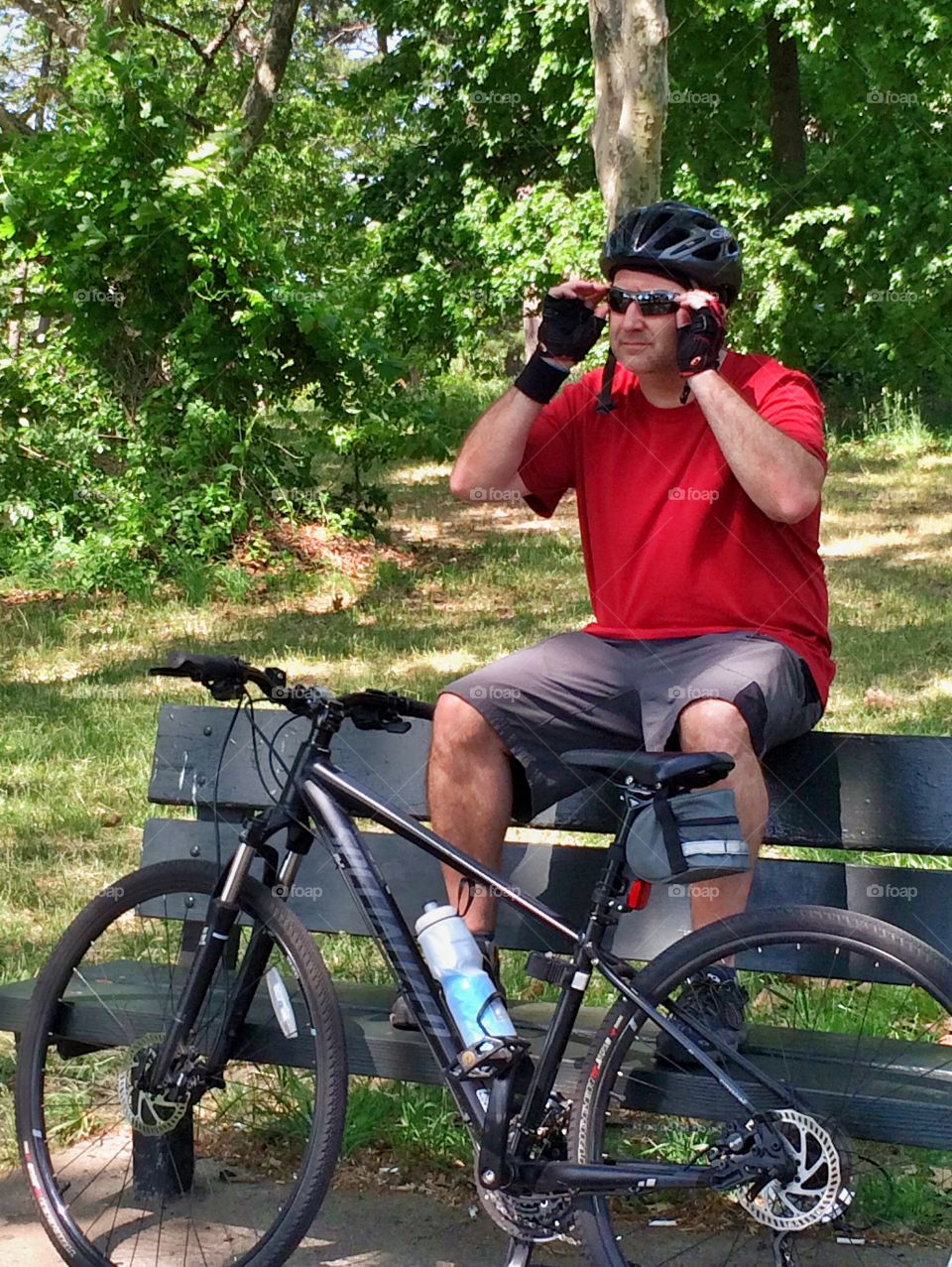 Biker resting on bench. Biker resting on park bench