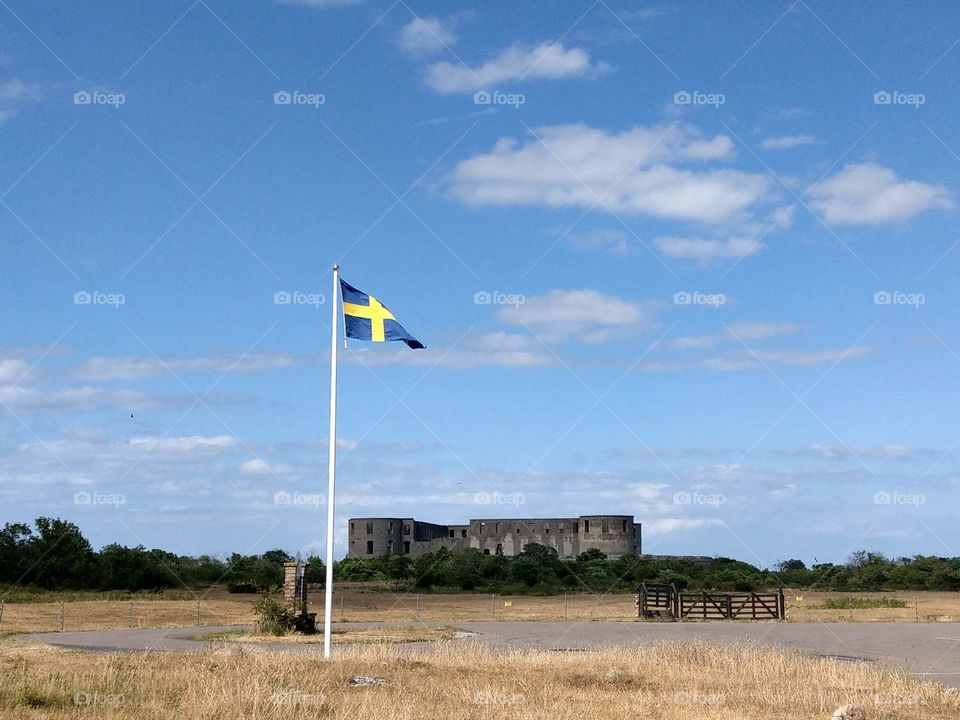 Swedish flag front of the ruins of the Borgholm castle, Oland island, Sweden