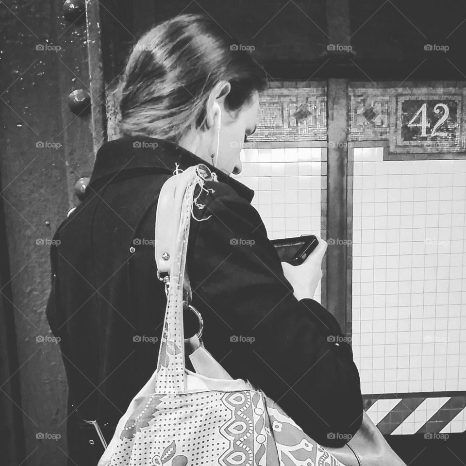 Girl in subway listening to the music on mobile