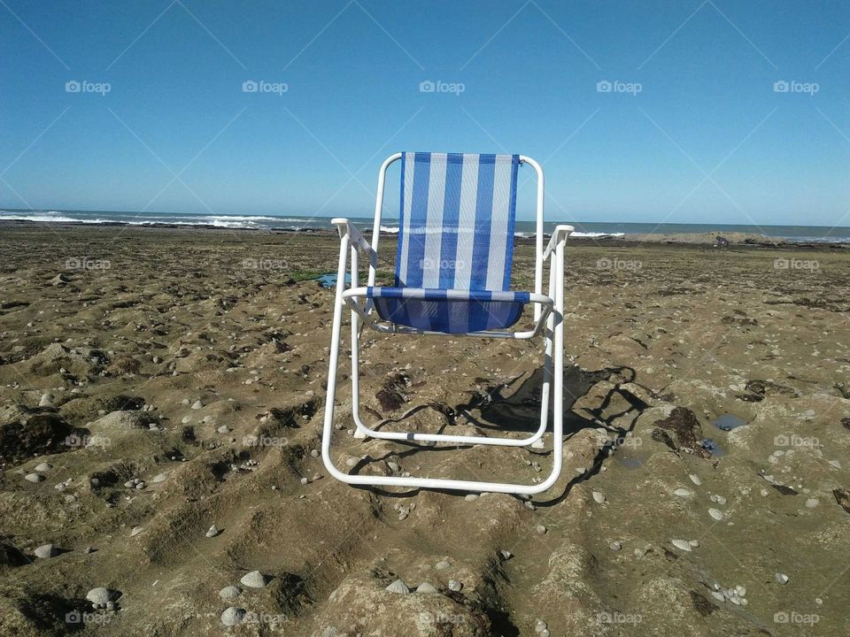 Beautiful chair on rocks near the beach at essaouira in Morocco.