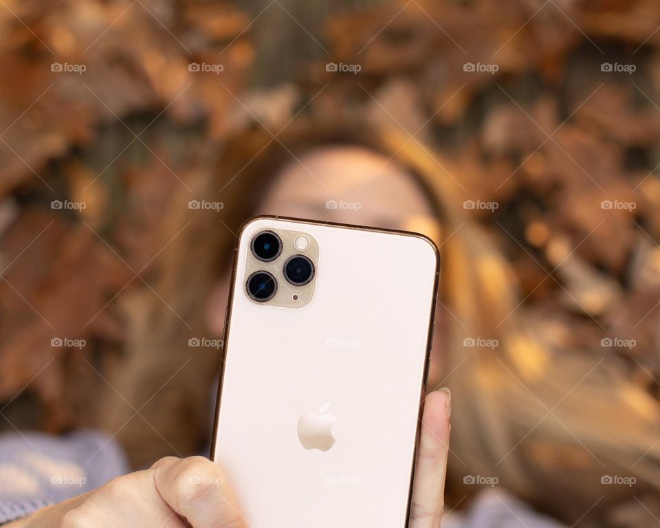 Woman taking a selfie with Autumn leaves