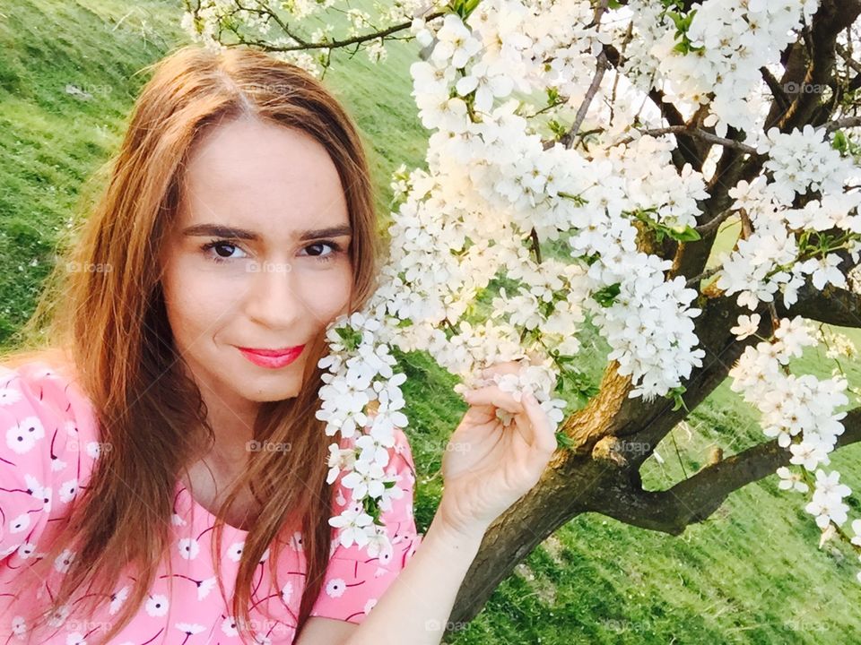 Spring portrait of woman surrounded by blooming trees
