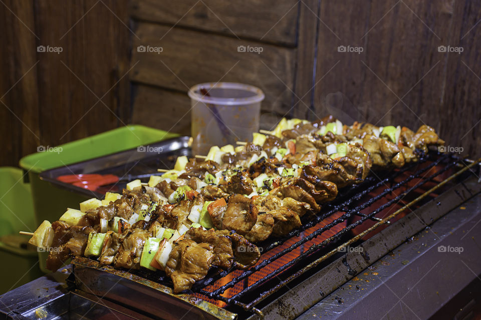 BBQ grilled meat with vegetables and tomato sauces on the steel grilles With the heat.