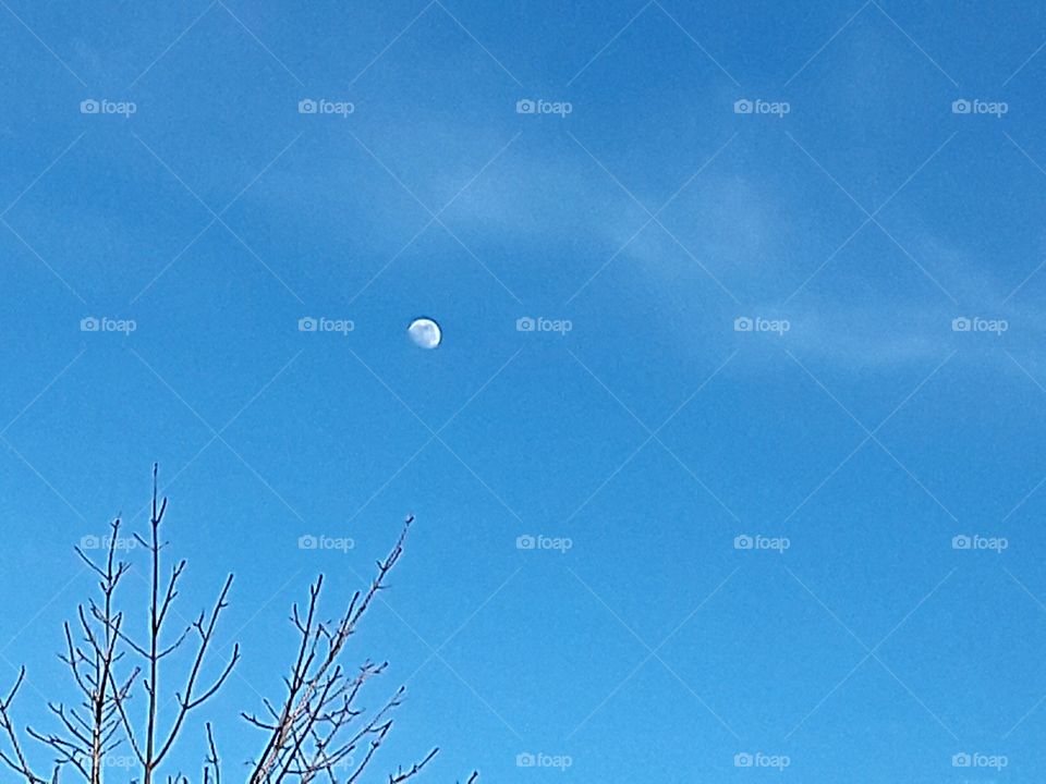 Moon appearing on a clear winters day...