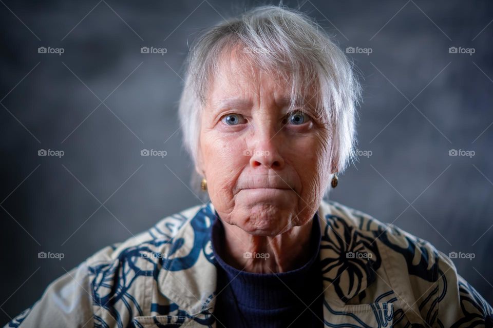 An elderly lady humorously expressing anger. 