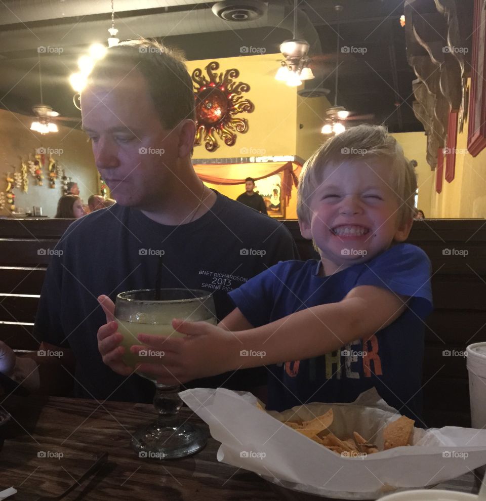 Sneaking a drink. Toddler tries to steal margarita 
