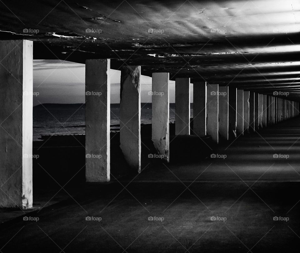 Black and white image of a seafront pedestrian underpass at dusk