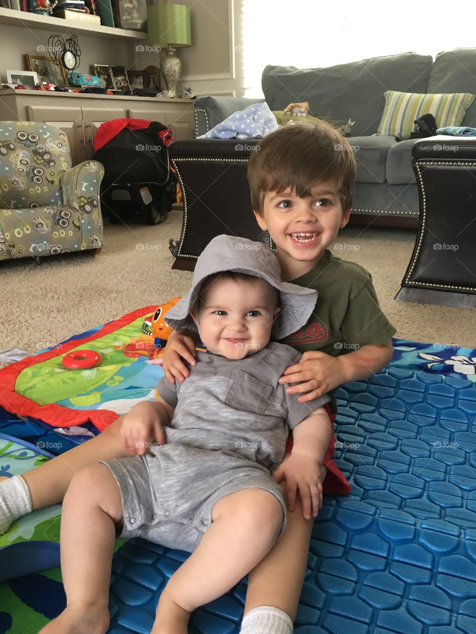 Brothers. Baby boy and toddler smiling together.