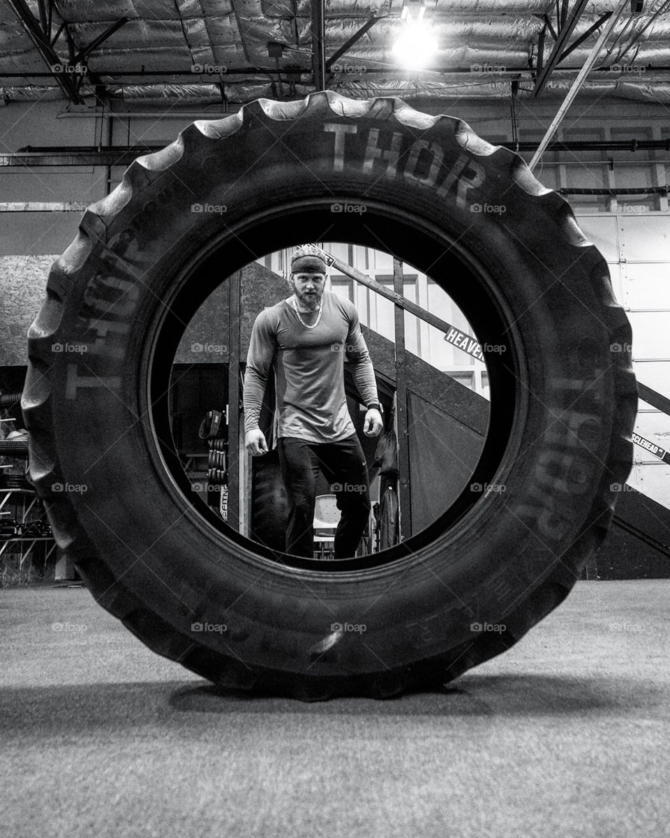 Athletic man in a gym with a tire 