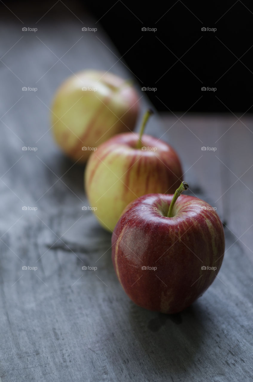 Tree apples in a row on table