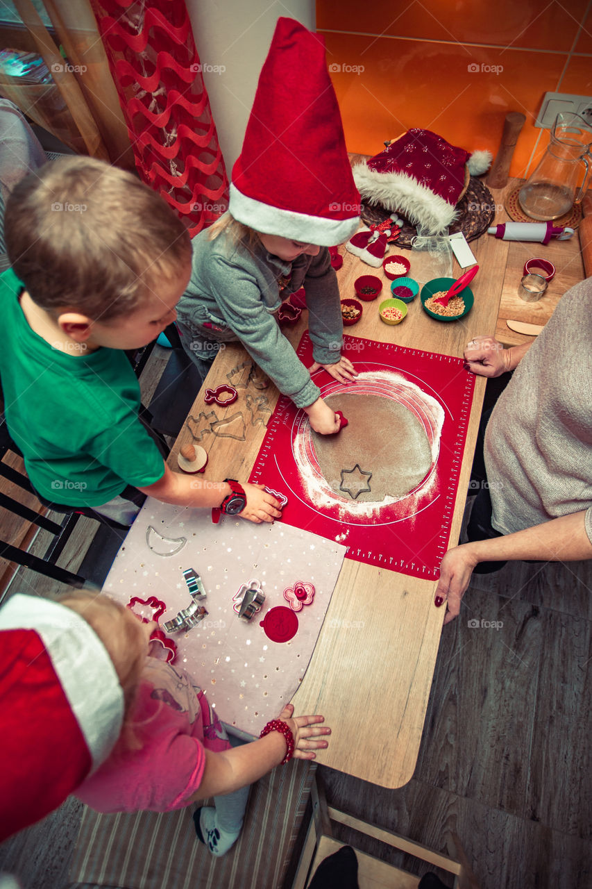 Baking Christmas cookies. Christmas gingerbread cookies in many shapes decorated with colorful frosting, sprinkle, icing, chocolate coating, toppers, put on table. Baking traditional cookies. Family celebrating Christmas. Baking at home