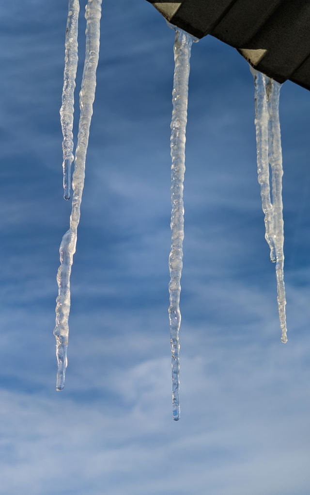 Melting icicles against the blue sky